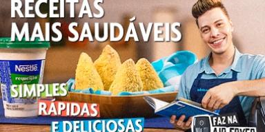 Fotografia mostra um rapaz segurando um livro e coxinhas ao lado.