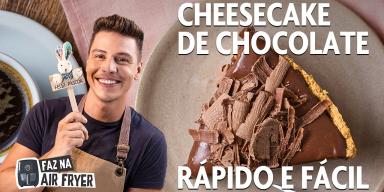 Fotografia mostra homem segurando um palito de madeira com coelho e cheesecake ao fundo.