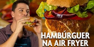 Fotografia mostra um rapaz mordendo um hambúrguer e uma foto de hamburguer no fundo.