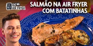 Fotografia mostra um rapaz sorrindo e um prato com salmão no fundo.