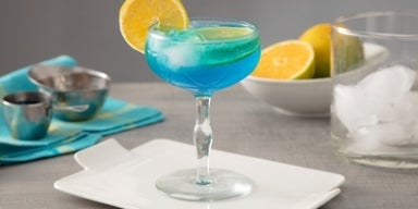 Drinks sem álcool: a nova sensação das festas Imagem de um copo de drink lagoa azul com uma rodela de laranja.