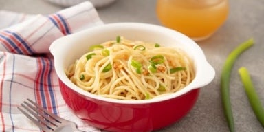 Imagem de um bowl vermelho com macarrão alho e óleo.