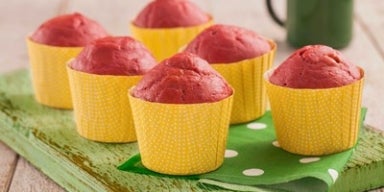 Muffin de beterraba em forminhas amarelas sobre uma tábua verde.
