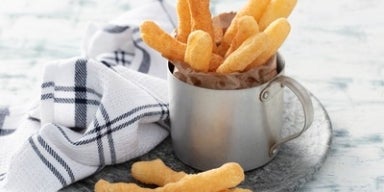 Imagem de um copo com palitos de biscoito de polvilho.