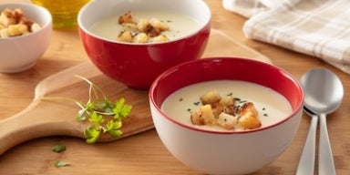 Imagem de dois bowls com sopa cremosa de batata com croutons.
