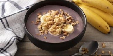 Tigela de açaí com banana fatiada e granola crocante.