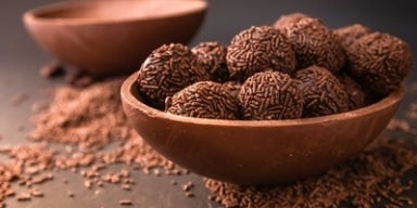 Ovo de chocolate aberto recheado com brigadeiros de chocolate com granulado.