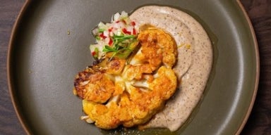 Bife de couve-flor marinado no missô, creme de cogumelos e castanha e vinagrete de talo de couve-flor.