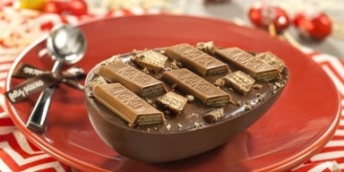 Prato vermelho com metade de um ovo de Páscoa recheado com kitkat em cima.