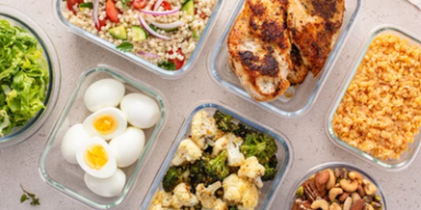 Marmitas com refeições saudáveis, incluindo legumes, ovos, frango grelhado, grãos e castanhas.