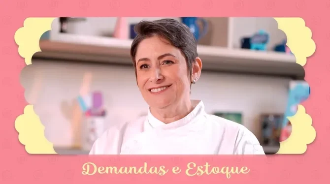 Fotografia com tons rosa, azul e amarelo, mostra uma mulher de cabelo curto, sorridente. Ao fundo um cenário de cozinha.