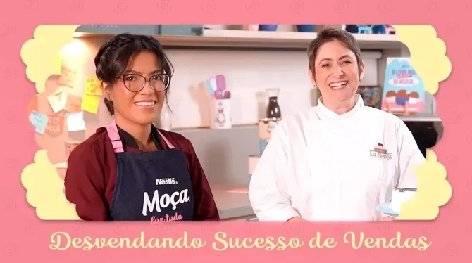 Fotografia com tons rosa, azul e amarelo mostra duas mulheres sorrindo: uma de roupa branca, outra de roupa escura e óculos.