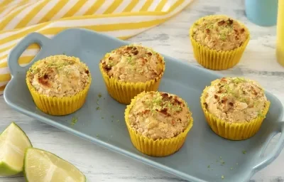 Foto da receita de Muffin de Limão. Observa-se uma bandeja de porcelana azul claro com 4 muffins em forminhas amarelas em cima, polvilhados com limão e NINHO em Pó. Foto da receita de Muffin de Limão. Observa-se uma bandeja de porcelana azul claro com 4 muffins em forminhas amarelas em cima, polvilhados com limão e NINHO em Pó.