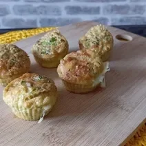 Imagem da receita de Muffin de queijo com brócolis, em uma tábua sobre uma mesa