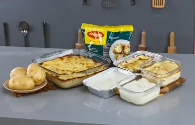 Imagem da receita de batata gratinada, em um recipiente de vidro e alumínio, ao lado de batatas e o produto  Tempero Fondor MAGGI