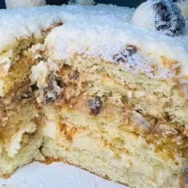 Foto da receita de Massa de Bolo de Leite Ninho. Observa-se um bolo de 3 camadas com doce de leite, ameixa e coco na cobertura.