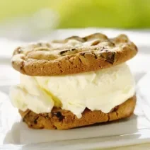 Fotografia de dois cookies e recheio de sorvete branco no meio.