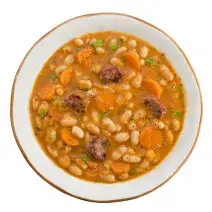 fotografia em tons de branco e laranja tirada de um prato redondo visto de cima dentro contém sopa