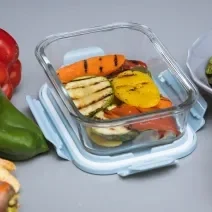 Foto da receita de legumes grelhados, em um recipiente de vidro, e ao lado alguns legumes crus que compõem a receita