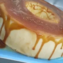 Foto da receita de Pudim Ligeiro. Observa-se um pudim com uma calda cor caramelo escorrendo.