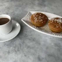 Imagem da receita de Muffin de Milho sem Glúten, em um recipiente branco e ao lado uma xícara de café