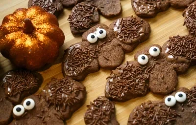 Fotografia de varios biscoitos de chocolates em formato de morcego decorados com granulado. Fotografia de varios biscoitos de chocolates em formato de morcego decorados com granulado.