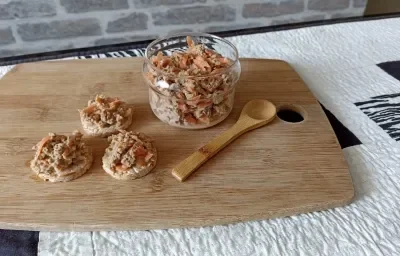 Imagem da receita de Patê de Atum Nutritivo, em um pote, sobre uma tábua e ao lado uma colher de madeira