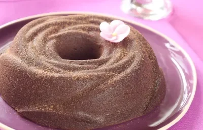 Fotografia de um brigadeirão sobre um prato rosa, decorado com uma flor rosa. Fotografia de um brigadeirão sobre um prato rosa, decorado com uma flor rosa.