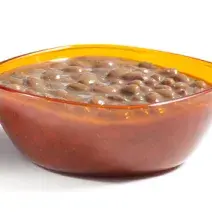 fotografia em tons de marrom tirada de um recipiente quadrado com feijão dentro