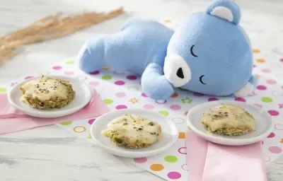 Foto da receita de Pizza de Abobrinha. Observa-se três pratinhos de sobremesa brancos, cada um com uma mini pizza de abobrinha com queijo derretido por cima. Guardanapos coloridos estão embaixo. Foto da receita de Pizza de Abobrinha. Observa-se três pratinhos de sobremesa brancos, cada um com uma mini pizza de abobrinha com queijo derretido por cima. Guardanapos coloridos estão embaixo.