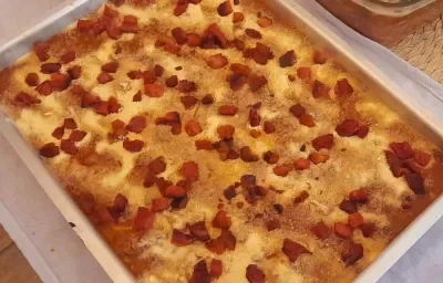 Foto da receita de Polenta com Bacon. Observa-se um recipiente refratário retangular com a preparação.