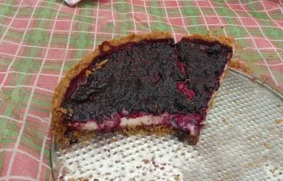 Foto da receita de Torta Ridícula. Observa-se 1/4 de torta sobre um recipiente refratário com geleia de amora por cima. Foto da receita de Torta Ridícula. Observa-se 1/4 de torta sobre um recipiente refratário com geleia de amora por cima.