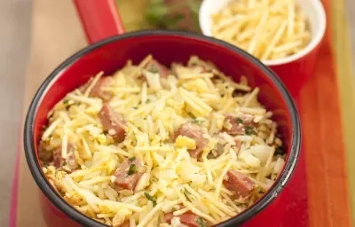 fotografia em tons de vermelho e amarelo de uma bancada vista de cima. Contém um pano nas cores vermelho, marrom e laranja, uma panela vermelha com pedaços de linguiça e babata palha e arroz. Ao fundo um potinho branco e redondo com batata palha fotografia em tons de vermelho e amarelo de uma bancada vista de cima. Contém um pano nas cores vermelho, marrom e laranja, uma panela vermelha com pedaços de linguiça e babata palha e arroz. Ao fundo um potinho branco e redondo com batata palha