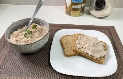 Imagem da receita de Patê de Atum em um prato branco sobre uma toalha em uma mesa