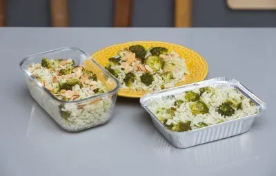 Foto da receita de Arroz com Brócolis em uma vasilha de vidro, uma forma de alumínio e sobre um prato amarelo, em cima de uma bancada Foto da receita de Arroz com Brócolis em uma vasilha de vidro, uma forma de alumínio e sobre um prato amarelo, em cima de uma bancada