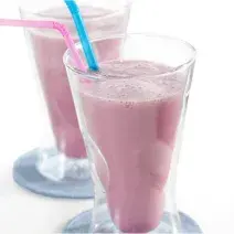 fotografia em tons de branco e rosa tirada de dois copos transparentes e ambos contém a vitamina