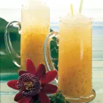 fotografia tirada de dois copos transparentes com o refresco de maracujá com gelo picado por cima