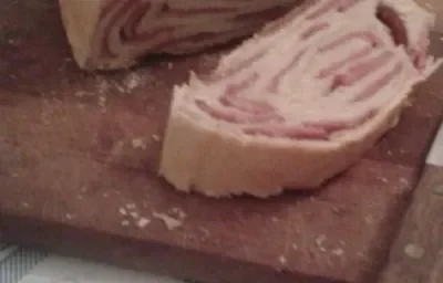 Foto da receita de pão de linguiça tartano servida em duas porções grandes cortadas ao meio sobre uma tábua de madeira Foto da receita de pão de linguiça tartano servida em duas porções grandes cortadas ao meio sobre uma tábua de madeira
