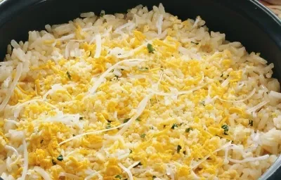 Uma panela comporta o arroz em tons amarelos. Uma panela comporta o arroz em tons amarelos.