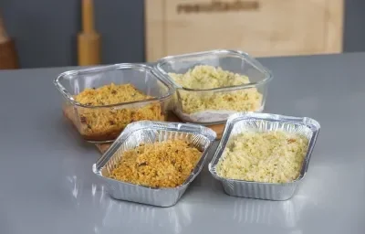 Foto da receita de Sobrecoxa em Crosta, em um recipiente de alumínio e vidro, sobre uma bancada Foto da receita de Sobrecoxa em Crosta, em um recipiente de alumínio e vidro, sobre uma bancada