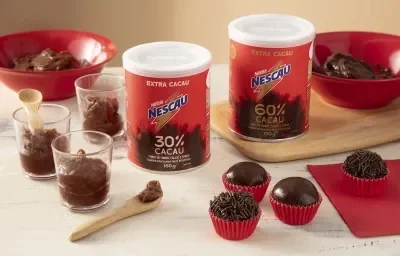Fotografia mostra brigadeiros de chocolate enrolados em forminhas de brigadeiro vermelha, e em copinhos de plástico transparente. Fotografia mostra brigadeiros de chocolate enrolados em forminhas de brigadeiro vermelha, e em copinhos de plástico transparente.
