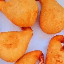 Foto da receita de Coxinha de Frango com Requeijão. Observa-se 5 coxinhas fritas sobre papel toalha.