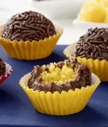 Imagem de um brigadeiro com recheio de bolo de cenoura em uma forminha amarela