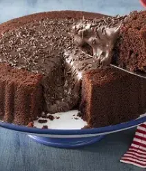 Imagem de um prato com um bolo de chocolate com brigadeiro e uma fatia sendo tirada