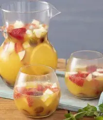 Imagem de uma jarra de ponche de frutas com dois copos