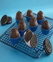 Foto da receita de Negresco Trufado. Observa-se um fundo azul claro com uma grade e 8 unidades da trufa de negresco