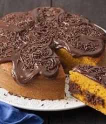 Foto de bolo de cenoura com cobertura e recheio de brigadeiro sobre um prato branco
