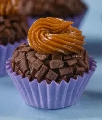 Fotografia de um brigadeiro enrolado com doce de leite decorando o topo. Fotografia de um brigadeiro enrolado com doce de leite decorando o topo.