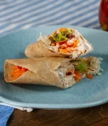 Fotografia mostra um lanche feito com wrap recheado com legumes e frango. Fotografia mostra um lanche feito com wrap recheado com legumes e frango.