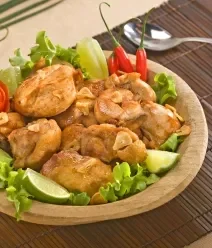 Receitas de Petiscos na Air Fryer Fotografia de um prato com frango à passarinho crocante, ao lado de um molho vermelho, em tons de marrom.